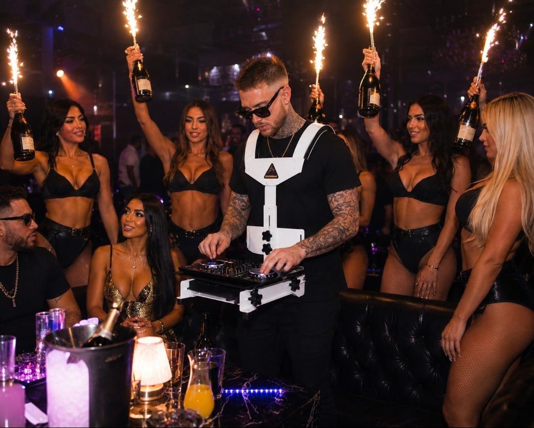 DJ using a white Walkabout carrier beside a nightclub bottle-service table